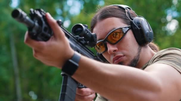 White Man Beard Protective Goggles Headphones Aiming Submachine Gun Outdoor — Stock video