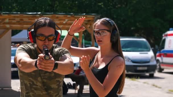 White Man Camo Shirt Safety Headphones Goggles Holding Handgun Female — Stockvideo