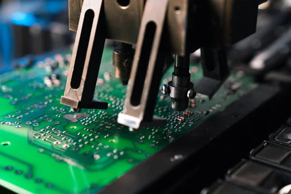 Makro yakın çekim yüzeye monte teknolojisi. Mikroçipler ve PCB 'nin yeşil yüzeyi gibi elektrik bileşenlerini bir arada tutan SMD montaj makinesi. Yüksek kalite fotoğraf