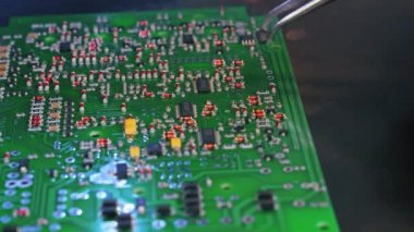 Baskılı devre kartının onarılması PCB 'nin cımbızla elektrik bileşenlerini elle monte etmesi. Tam onarım işi. Yakın plan. Yüksek kalite 4k görüntü
