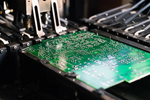 Printed circuit board as the board base for various electric components being placed on it by SMD montage machine. Closeup shot. High quality photo