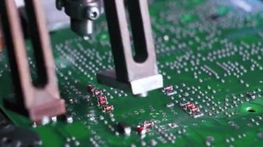 PCB baskılı devre kartında elektriksel bileşenleri birleştiren SFD yüzey montajı cihazını kapat. Modern teknoloji. Yatay çekim. Yüksek kalite 4k görüntü