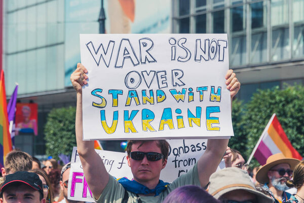 June 25, 2022 Warsaw, Poland - A person holds a placard saying War is not over. Stand with Ukraine during the Warsaw Equality Parade. This year the Warsaw Equality Parade hosted the Kyiv Pride - the