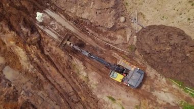 Varşova, Polonya 'da bir inşaat sahasında çalışan Dünya' yı yerinden oynatan kazıcı. Hava görüntüsü. Yüksek kalite 4k görüntü