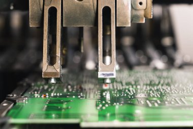 Basılı devre kartı PCB üzerinde çalışan SMD yüzey montaj cihazının yakın çekim görüntüsü. Elektrik bileşenleri monte ediliyor. Hassas teknoloji. Yatay