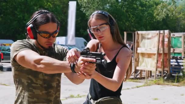 Weibliche Kaukasische Schießlehrerin Korrigiert Die Haltung Eines Muskulösen Kaukasischen Bärtigen — Stockvideo