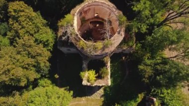 Ortodoks kilisesinden arta kalanlar. Issız bir yerde, yüksek ağaçlarla çevrili terk edilmiş eski tuğla kilise. Kuş bakışı bakış açısı. Yüksek kalite 4k görüntü