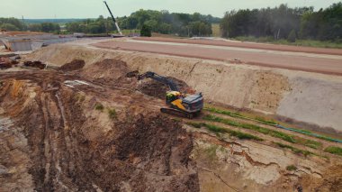 Uzun menzilli sürüngen kazıcısı bir inşaat sahasında toprağı hareket ettiriyor, boru hatları döşemek için siperler kazıyor. Varşova, Polonya. - Evet. Yüksek kalite fotoğraf