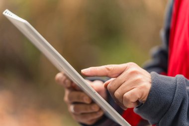 Tanımlanamayan beyaz erkek mühendis taşınabilir laptop ekranının planına bakıyor ve parmağıyla işaret ediyor. Arka plan bulanık. Açık hava çekimi. Yüksek kalite fotoğraf
