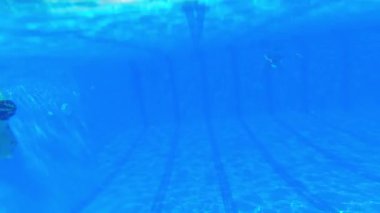 Yaz tatili konsepti. Turkuaz yüzme havuzunun altına yerleştirilmiş kamera otelin yüzme alanını gösteriyor ve yüzme havuzunun tabanını kaydediyor. Yüksek kalite 4k görüntü