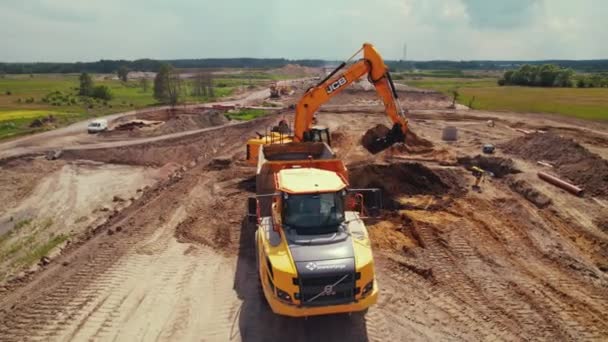 Penggali Jarak Jauh Memuat Tanah Digali Dalam Truk Lokasi Bangunan — Stok Video