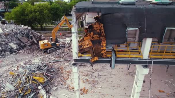 解体工事中の建物 油圧シアーを備えた掘削機が建物を破壊する ポーランドのワルシャワ ドローンの空中ビュー 高品質4K映像 — ストック動画