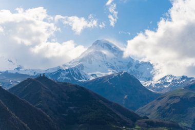 Arka planda Gergeti Trinity Kilisesi ve Mkinvartsveri 'nin yükselen manzarası, Kazbegi, Gürcistan. Yüksek kalite fotoğraf