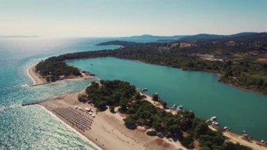 Port Glarokavos, Paliouri, Kassandra Yunanistan. Güneşli, mükemmel yaz havası. Turkuaz sudan, turistik plajlardan ve açık mavi gökyüzünden oluşan hava perspektifi. Yüksek kalite 4k görüntü