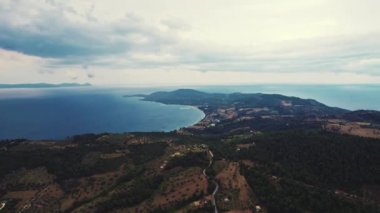 Kassandra 'daki geleneksel Palouri köyünün insansız hava aracı görüntüsü. Yürüyüş için harika bir yer. Sakin denizin üzerinde bulutlarla dolu bir gökyüzü. Yüksek kalite 4k görüntü