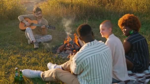 Unga Vuxna Vänner Umgås Runt Lägerelden Fält Camping Spela Musik — Stockvideo