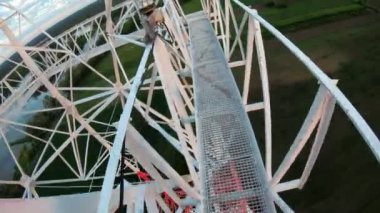 Alışılmadık hobiler - koruyucu giysi olmadan tırmanmak. Cesur bir insan beyaz metal platformda yürüme pozisyonunu çok yüksekte gösteriyor. Yüksek kalite 4k görüntü