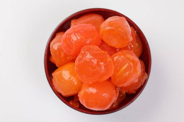 Yuvarlak turuncu tuzlu yumurta sarısı pasta malzemesi üzerine küçük siyah kâse beyaz arka plan yakın plan makro.