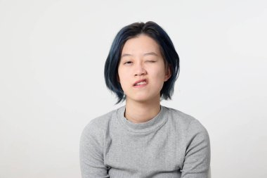 Genç ve çekici Asyalı Malezyalı kadın beyaz arka plan göz kırpmasında yüz ifadesi modu ifadesi takınıyor