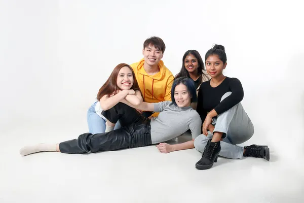 Group of young south east asian mixed race man woman chinese malay indian sit lying pose on floor enjoy relax fun talk gather pose students colleagues look at camera