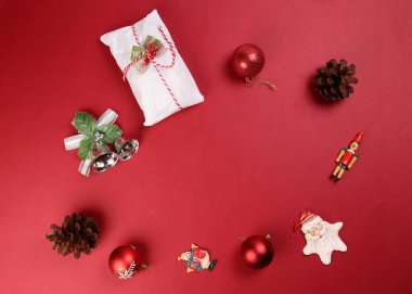 Noel xmas dekorasyon süsü hediye paketi kırmızı arka planda çalınmış meyveli kek çam meyvesi.