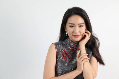 Güzel, genç, zarif Güneydoğu Asyalı kadın modern Çin Cheongsam elbisesi giyiyor. Gülümse.