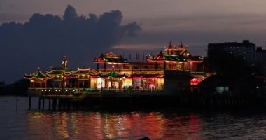 Georgetown, Penang, Malezya 3 Şubat 2022 Hean Boo Thean 'ın renkli ışıkları günbatımında suyun üzerinde yüzen tapınak olarak da bilinir.. 