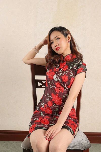 漂亮的年轻女子穿着漂亮的中式旗袍 端坐着 — 图库照片