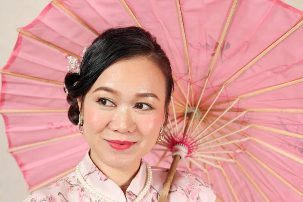 매력적 이색갈 우산으로 포즈를 취하며 중국의 드레스를 — 스톡 사진
