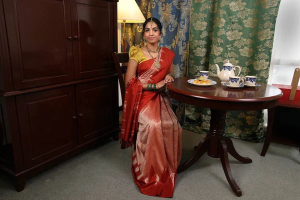 美しいです若いです女性身に着けているインドの参照ドレスポージングホームレトロヴィンテージテーブル設定 — ストック写真