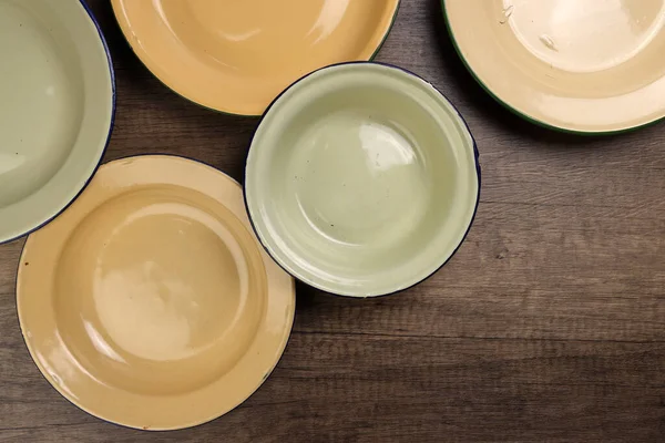 Enamel teneke metal tabak çanağı antika sofra takımı kırsal ahşap arka plan manzaralı.