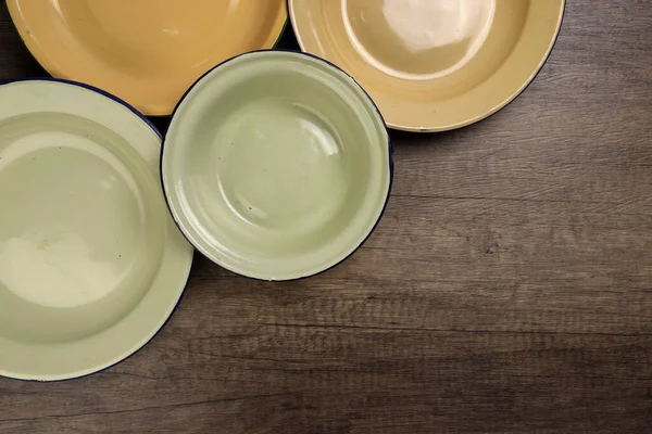 Enamel teneke metal tabak çanağı antika sofra takımı kırsal ahşap arka plan manzaralı.