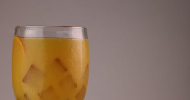 Крупный План Вращающийся Стекло Заполнить Апельсиновым Соком Льда Кубика Мороз — стоковое видео