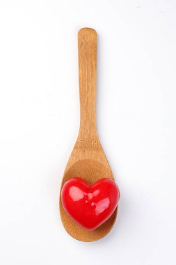 Tahta kaşığın üzerinde beyaz arka planda 3 boyutlu 3 boyutlu kırmızı harp şekli sembolü