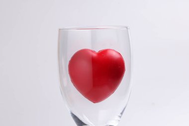 Beyaz arkaplanda 3 boyutlu kırmızı harp sembolü olan şeffaf şarap kadehi metin alanı