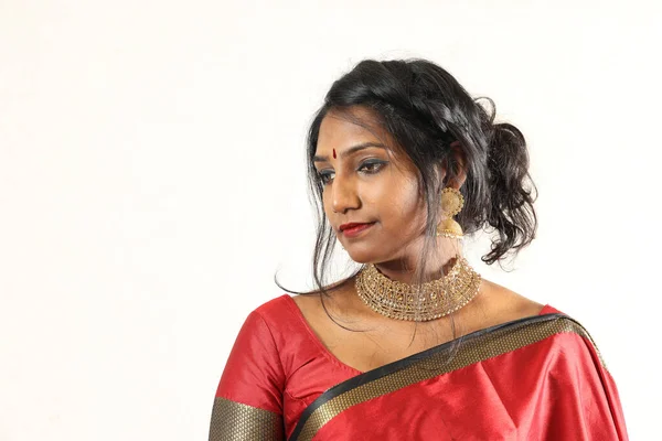 Indian woman wearing red orange traditional royal saree jewellery choker set necklace jhumka earring maang tikka waist chain stand pose look see smile mood expression at old rustic room background