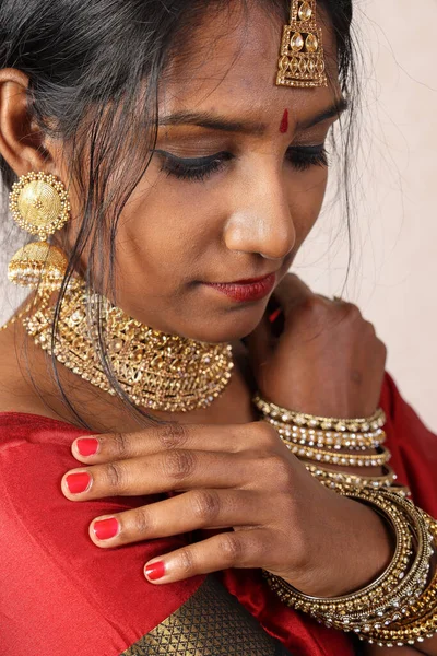 Indian woman wearing red orange saree jewellery choker set necklace jhumka earring maang tikka waist chain stand pose look see smile mood expression look