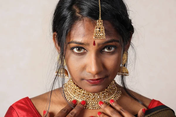 Indian woman wearing red orange saree jewellery choker set necklace jhumka earring maang tikka waist chain stand pose look see smile mood expression look