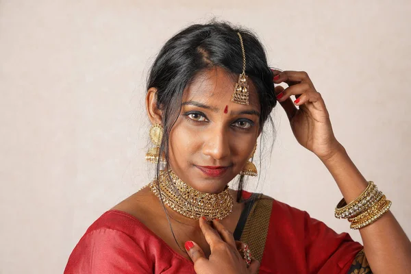 Indian woman wearing red orange saree jewellery choker set necklace jhumka earring maang tikka waist chain stand pose look see smile mood expression look