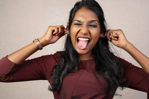 Asian Indian origin dark skin tone beautiful woman facial hand expression making faces hand signs funny tongue out