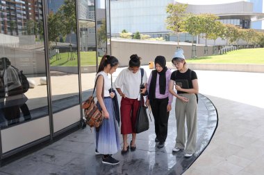 Dört çekici Asyalı kadın arkadaş arkadaş arkadaşlar bahçe çatısı inşaatı öğrencileri. Sohbet. Arka arkaya fotoğraf standı. 