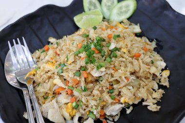 Tayland usulü kızarmış tavuk, siyah tabakta salatalık dilimleri. 