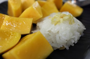 Yapışkan pirinçli Tayland usulü mango üzerine çıtır çıtır sarı mercimek.