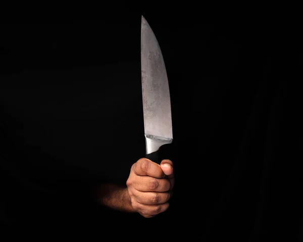 Asian male dark skinned single hand fist finger on black background holding stainless steel knife
