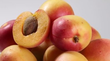 Fresh ripe juicy yellow orange red apricot fruit pile whole cut half slice seed on rustic wood background flat lay top view pan move shift 