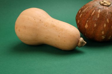 Taze, olgun, sarı tereyağı kabağı yeşil arka planda küçük kahverengi balkabağı. 