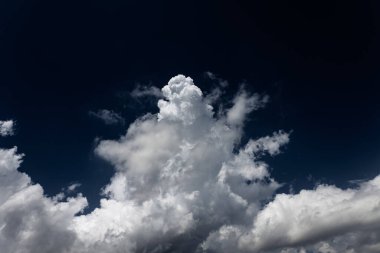 Gerçekçi olmayan beyaz bulutları olan çok güzel mavi bir gökyüzü. Yumuşak odaklanma. Yatay fotoğraf