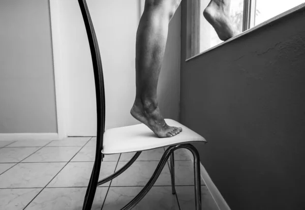 Das Mädchen Steht Auf Einem Stuhl Aus Dem Fenster Springen — Stockfoto