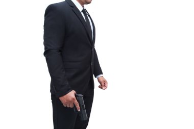 Siyah takım elbiseli silahlı bir adam, izole edilmiş beyaz bir arka planda, sert duruşta duran bir tabanca. Suikastçı, katil, suçlu kavramı.