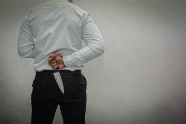 Bıçak katili. Beyaz gömlekli, siyah pantolonlu ve sırtında bıçak tutan bir adam. beyaz arkaplan